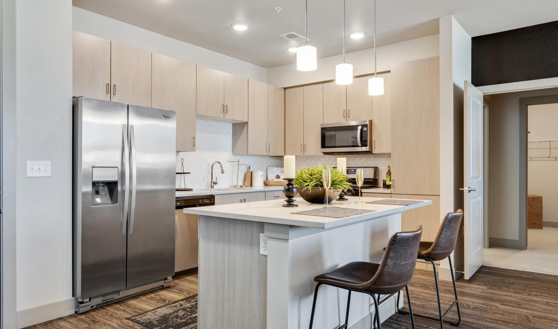 a kitchen with a fridge and chairs