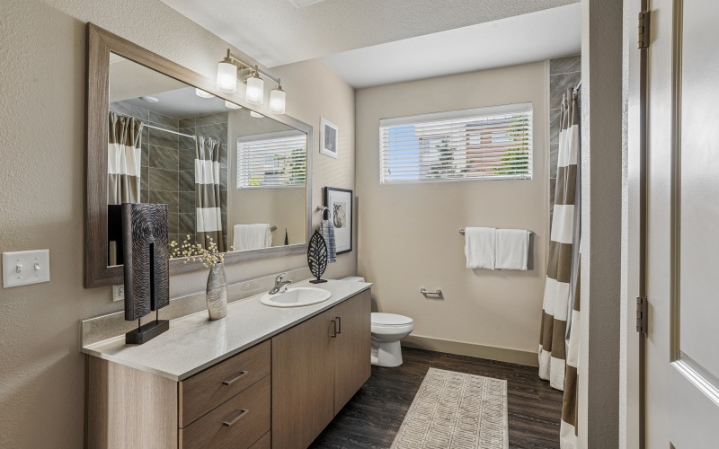 Large secondary bathrooms with wood framed mirrors and ample cabinet storage. Plus natural lighting.